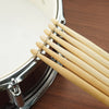A close-up view of premium maple drumsticks resting on a cymbal stand.