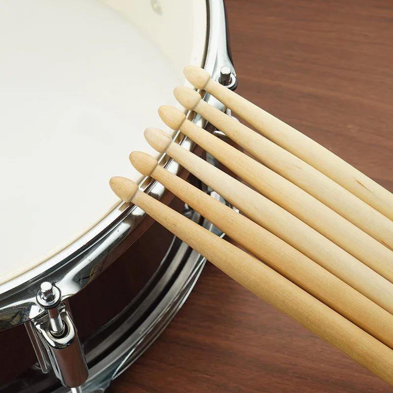 A close-up view of premium maple drumsticks resting on a cymbal stand.