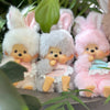 A collection of fluffy, light-colored Monchhichi plush toys with pink accents and large ears.