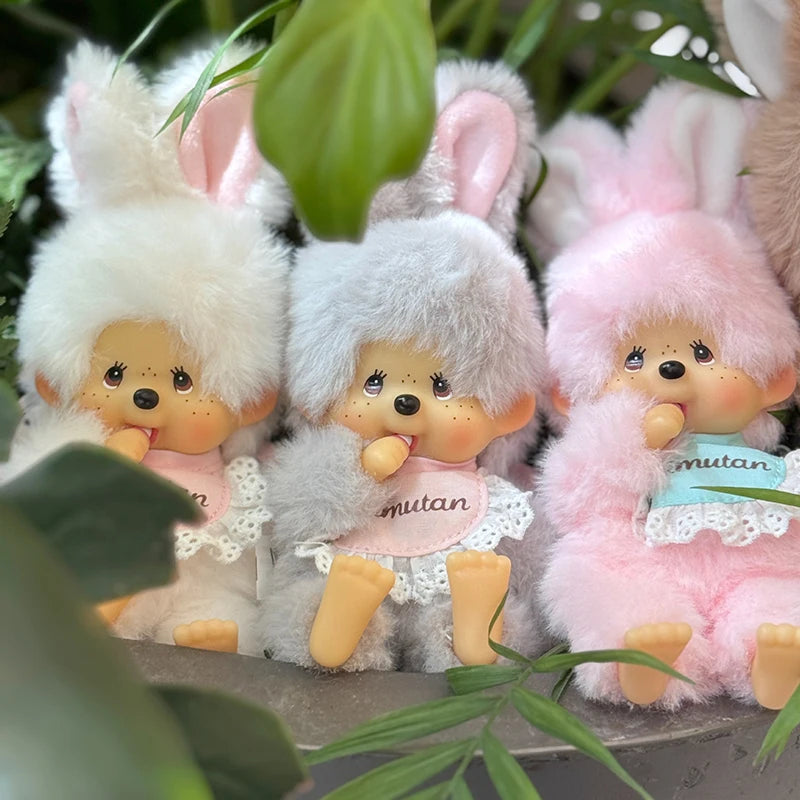 A collection of fluffy, light-colored Monchhichi plush toys with pink accents and large ears.