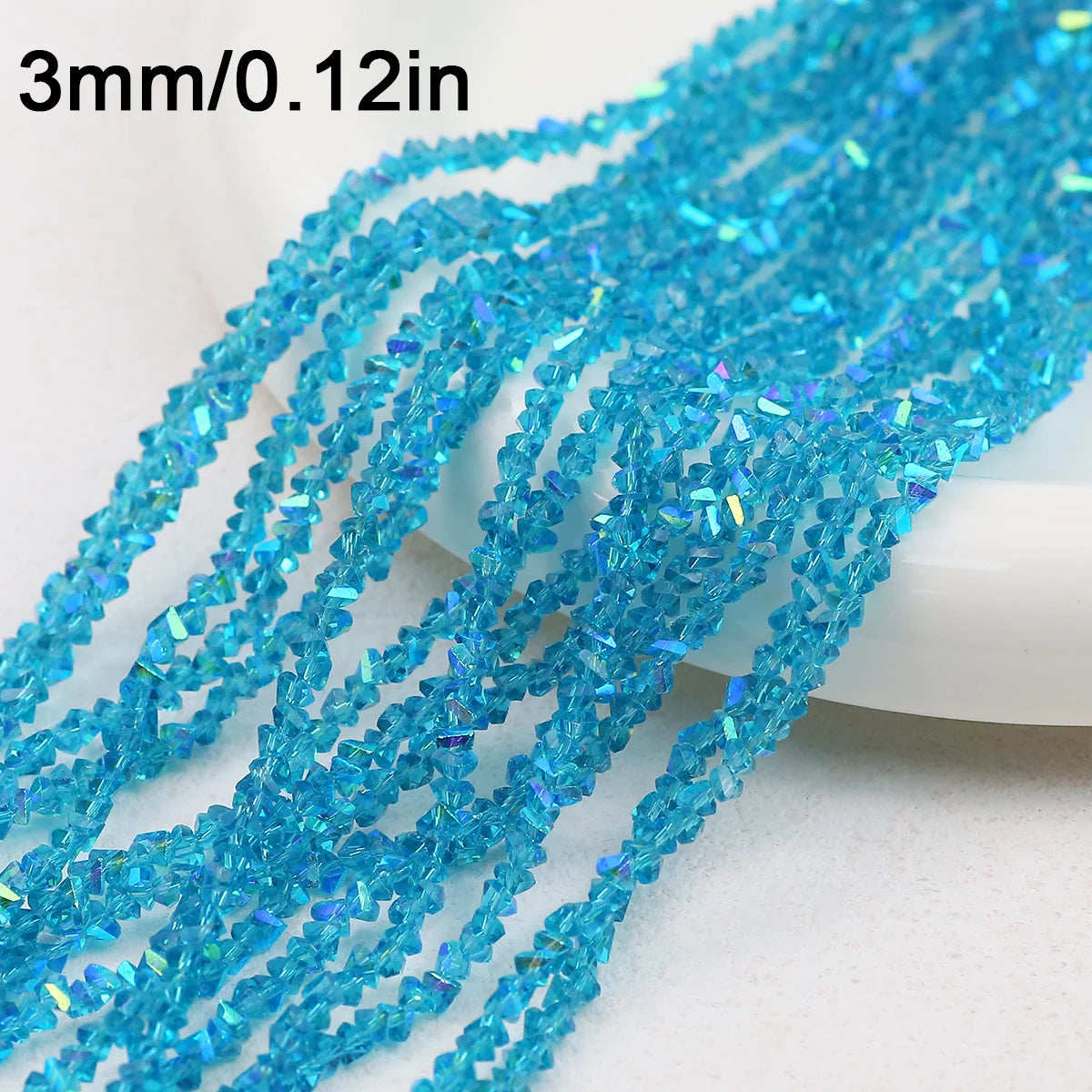 A close-up of blue crystal triangle beads, measuring 3mm or 0.12 inches, arranged in strands.