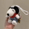 A white Snoopy plush toy with black ears and sunglasses is being held, attached to a white cord.