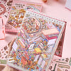 A hand holds an open sticker book featuring colorful 3D cabin scenes and creative designs.