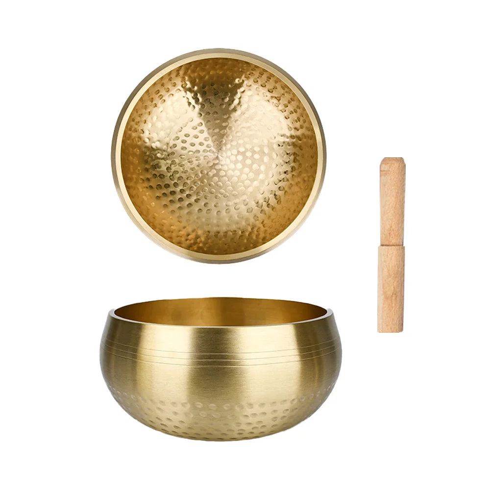 A pair of handcrafted brass Tibetan singing bowls, including a bowl and a mallet.
