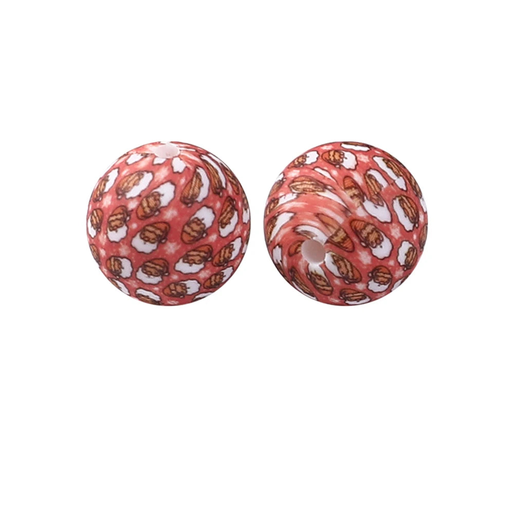 A pair of round, reddish-orange silicone beads with a pattern resembling dried leaves or petals.
