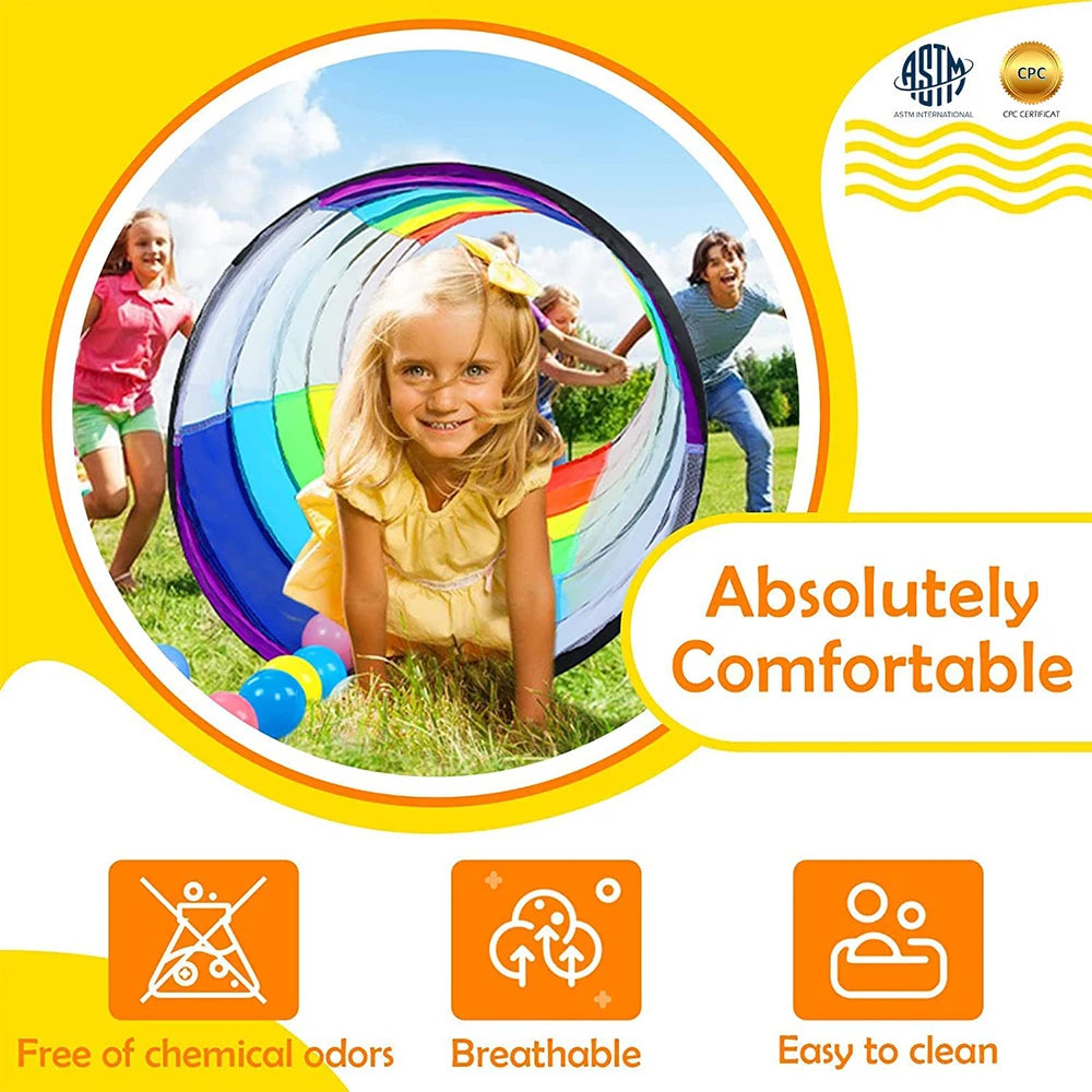 A young girl is playing inside a colorful pop-up play tunnel outdoors.