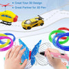 Hands are using a pink pen to draw a butterfly design on paper, with various colored filament tubes nearby.