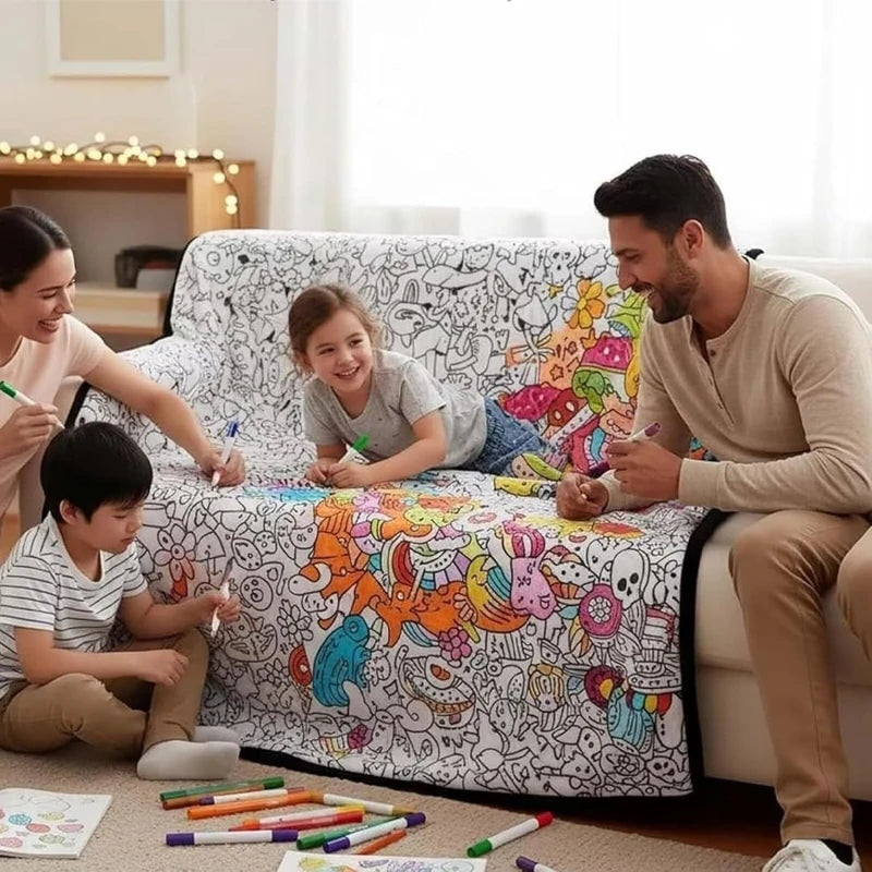 A family is coloring on a blanket with markers in a bright living room setting.