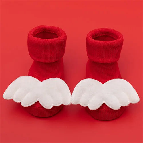 Pair of red baby anti-slip cotton socks with white festive Christmas wing designs