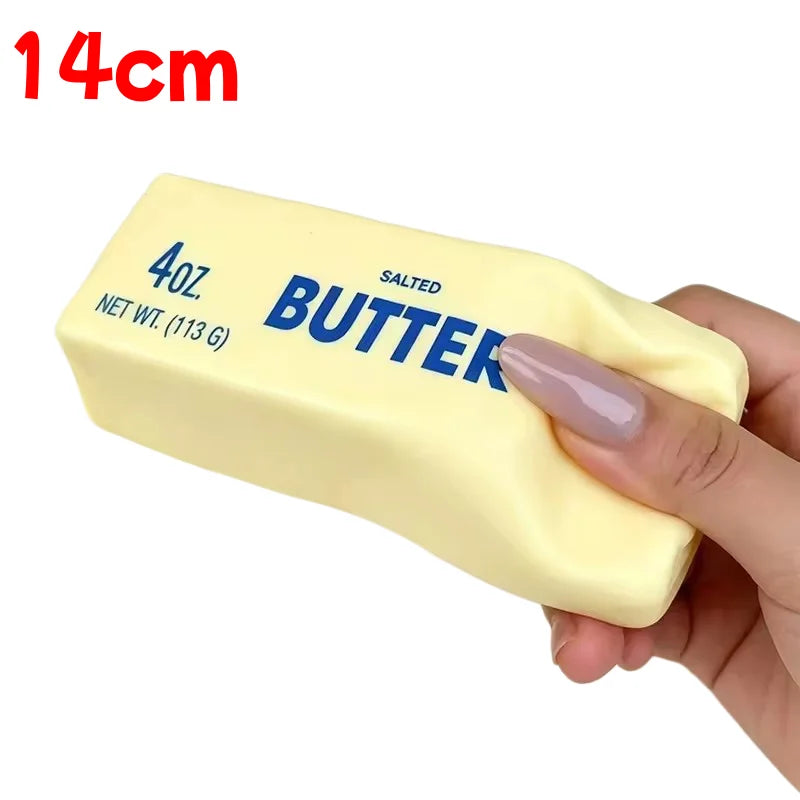 A hand holds a yellow butter stick squishy toy labeled 4oz salted butter.