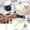 A hand holds a bright lime green nylon drumstick near a drum kit, demonstrating the durable and easy-to-use features.