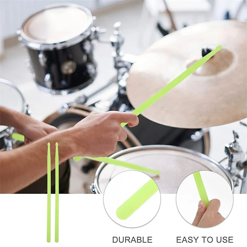 A hand holds a bright lime green nylon drumstick near a drum kit, demonstrating the durable and easy-to-use features.