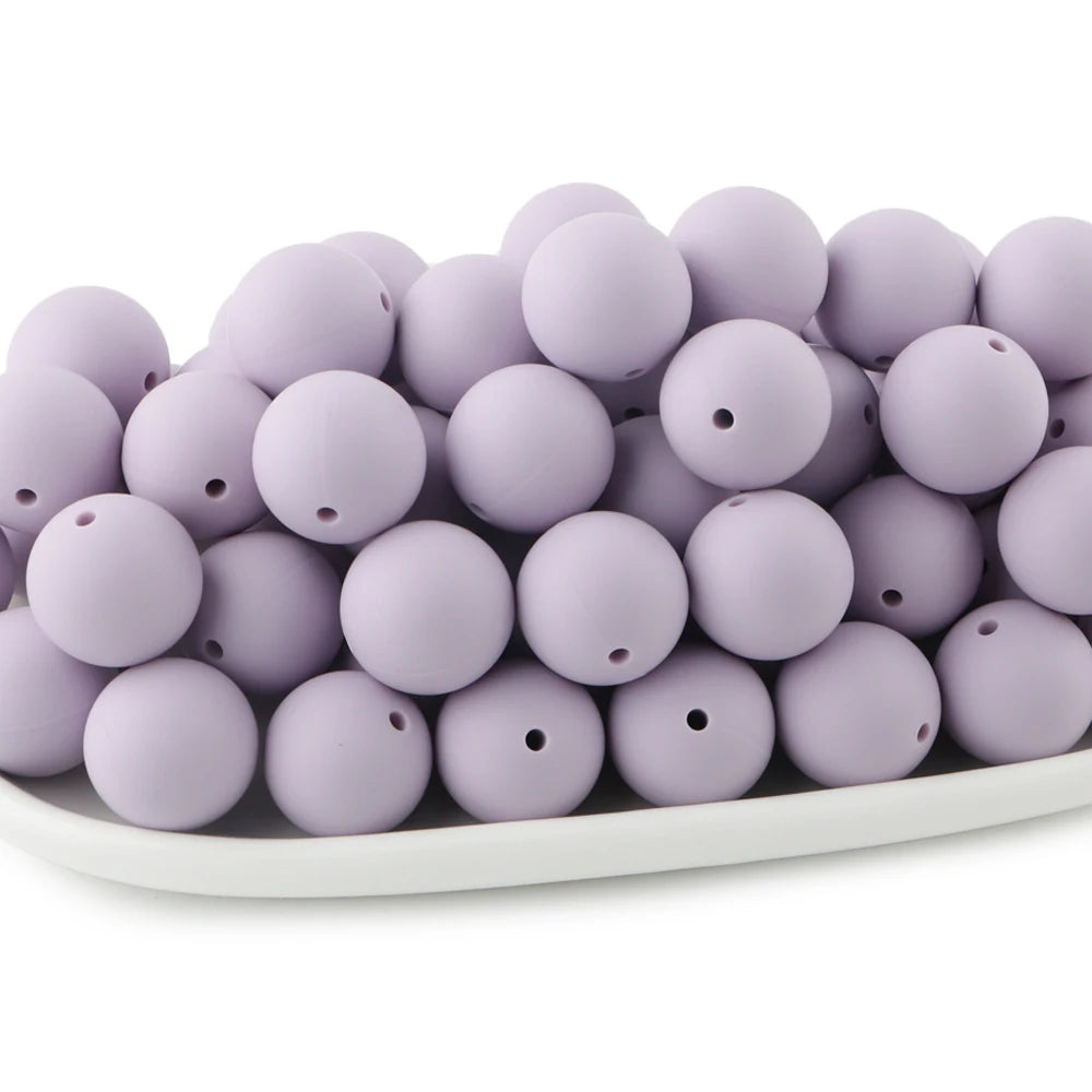 A pile of round, light purple silicone beads for jewelry making and DIY crafts.