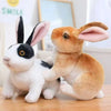 A fluffy white and black rabbit plush toy sitting on a wooden surface.