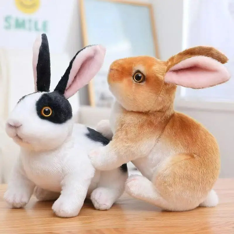 A fluffy white and black rabbit plush toy sitting on a wooden surface.