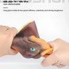 A hand is holding a realistic brown dinosaur hand puppet with an orange claw and a green eye.