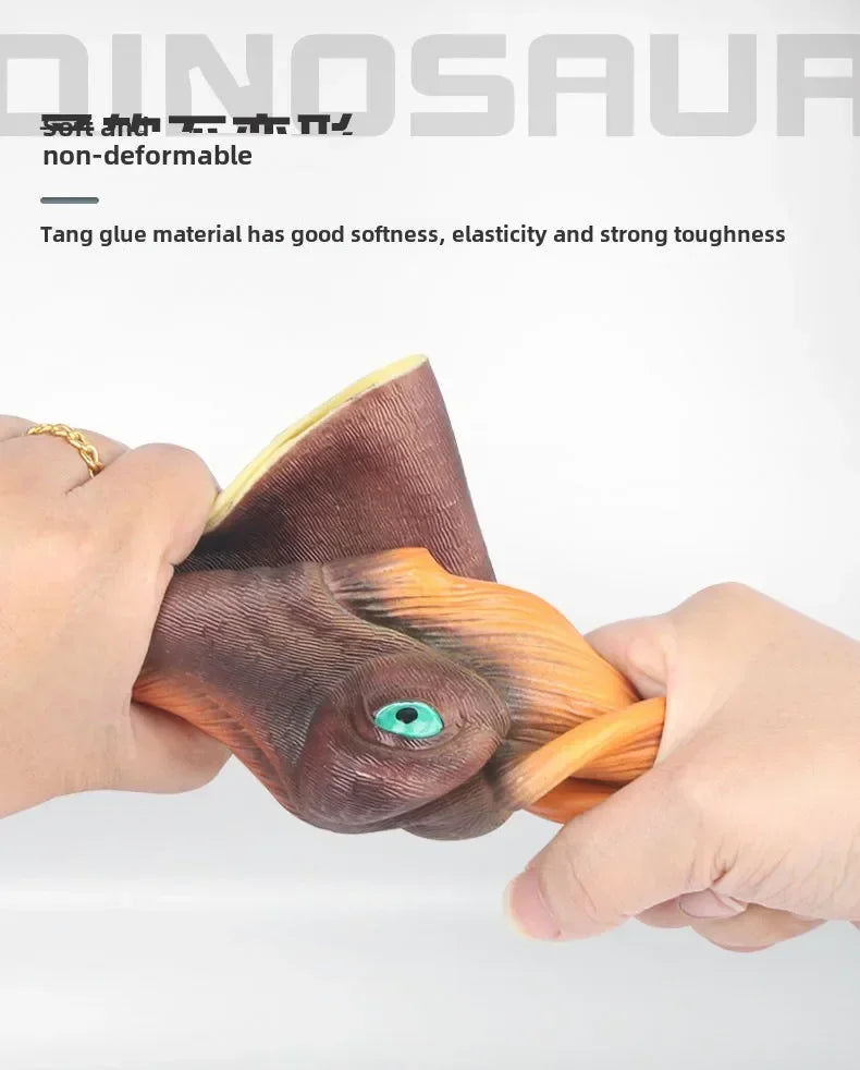 A hand is holding a realistic brown dinosaur hand puppet with an orange claw and a green eye.