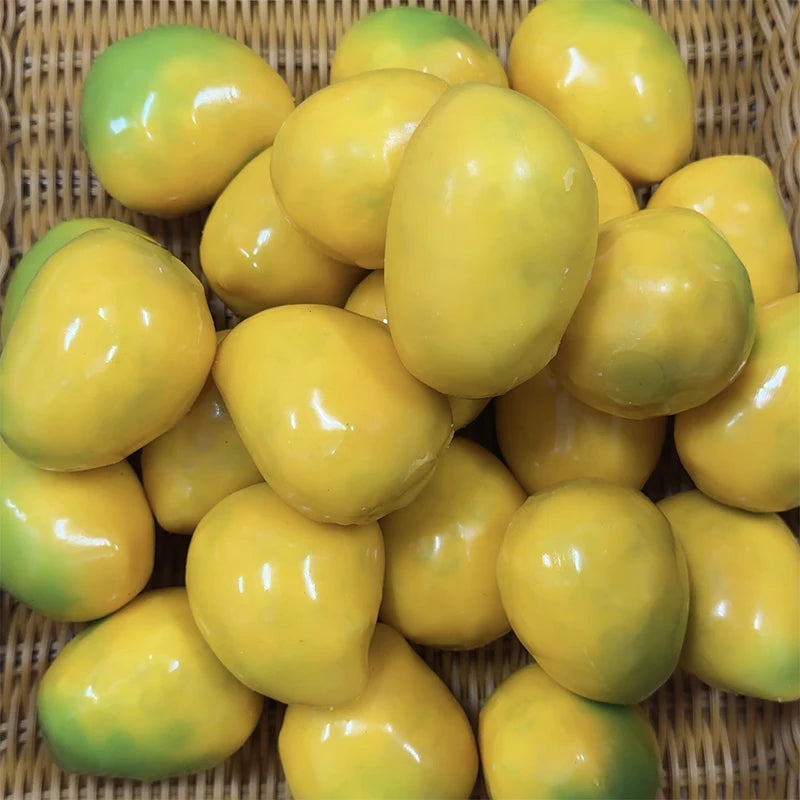 A pile of bright yellow and green crispy mango stress balls in a woven basket.