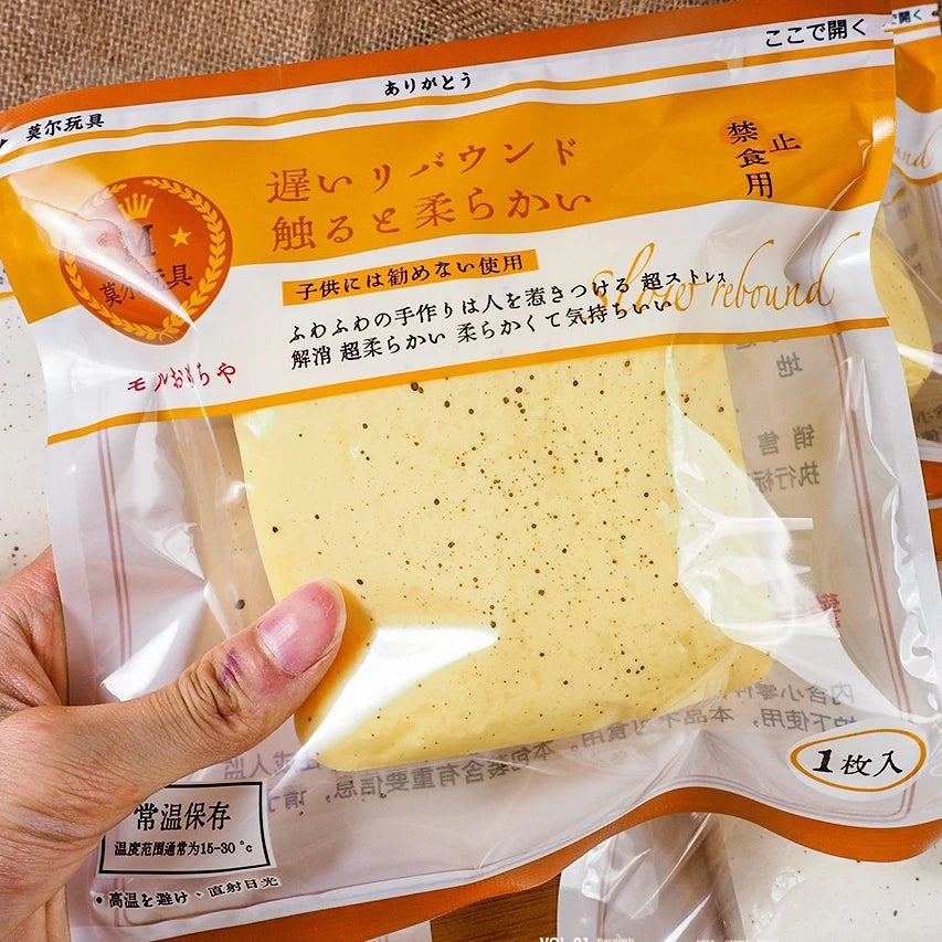 A yellow squishy stress relief toy shaped like toast is shown in a clear plastic bag.