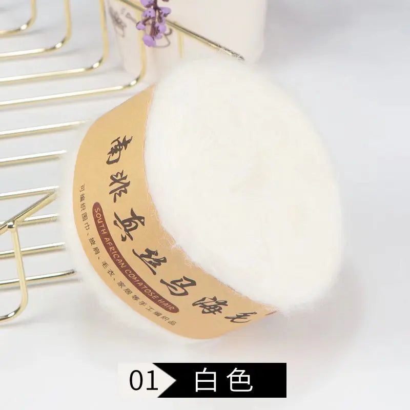 A white ball of silk mohair blended yarn is shown next to a gold wire hanger.