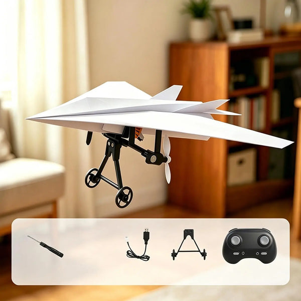 A white RC paper airplane kit with a gyro stabilizer is shown in a studio setting.