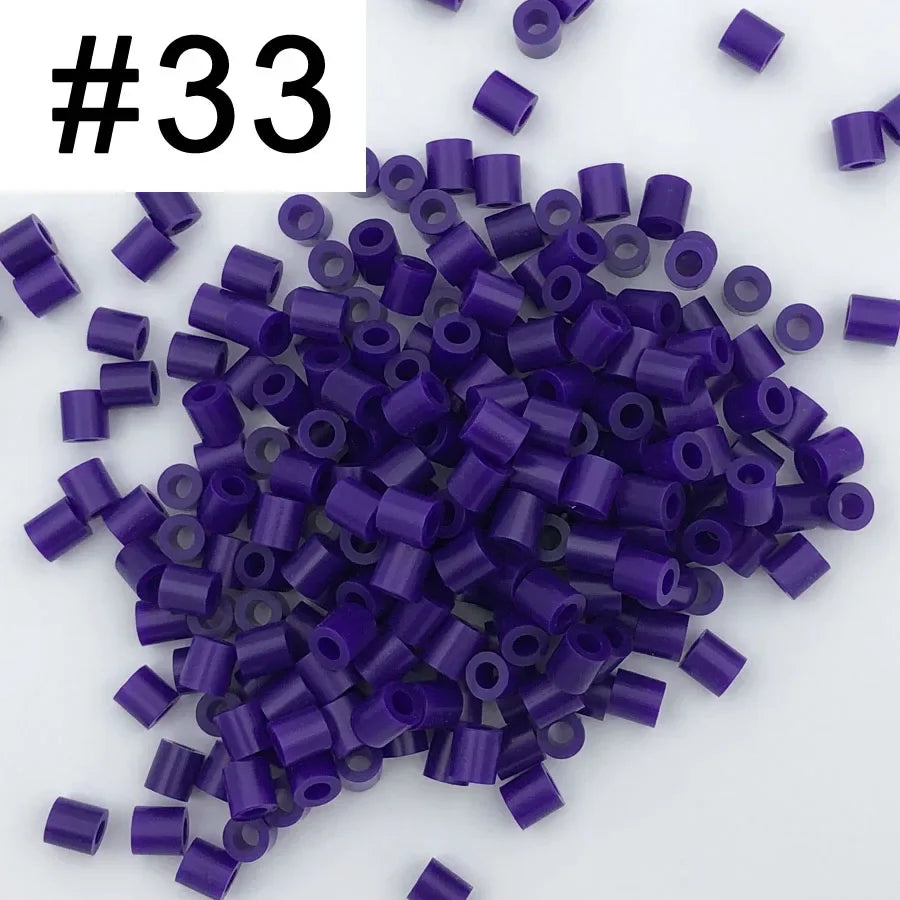A pile of 1000 small purple and blue fuse beads for creative craft projects.