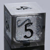 A close-up view of a translucent black polyhedral dice set, including a d9 and a d5, resting on a dark surface.