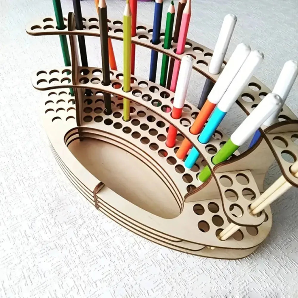 A wooden organizer holds numerous colored art brushes and pencils in individual slots.