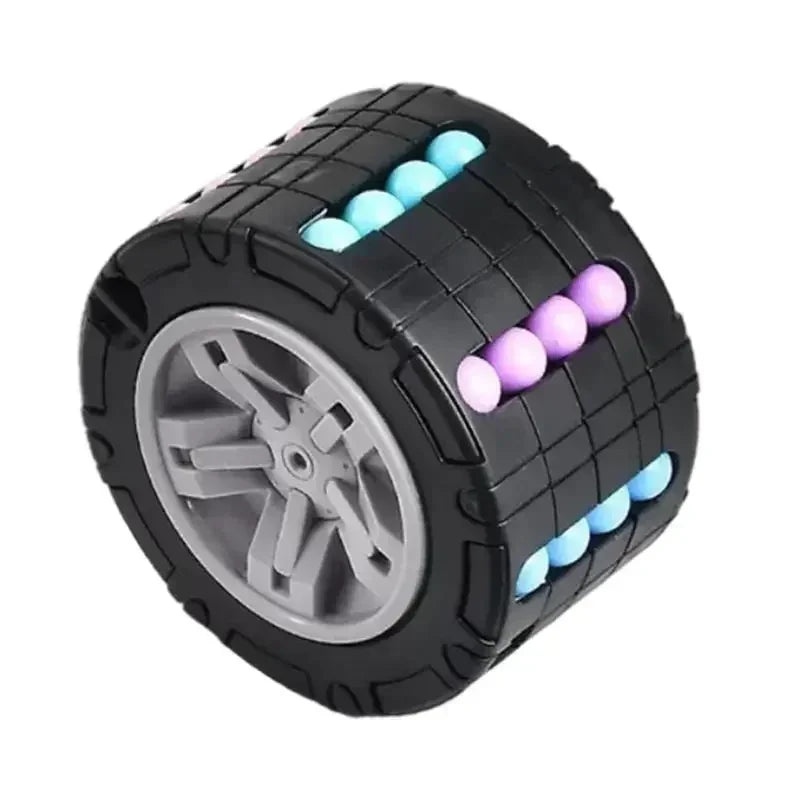 A black 3D rotating slide puzzle cube with colorful plastic balls on the top and a clear wheel on the bottom.