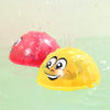 A yellow light-up bath toy is spraying water, with a red version nearby.
