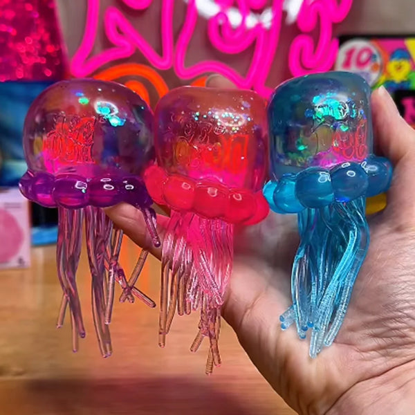 Three translucent squishy jellyfish toys in purple, pink, and blue are held in a hand.
