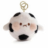 A white and black spotted plush character with a gold-colored keychain attached.