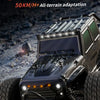 A silver high-speed off-road speed vehicle with large tires and LED lights on a rocky terrain.