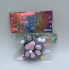 A squishy stress relief toy shaped like a pink and white cat paw is packaged in a clear plastic bag with a colorful card.