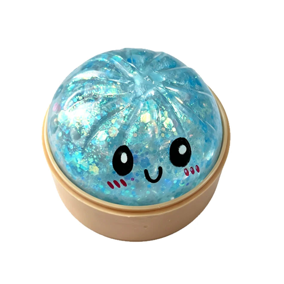 A round, translucent blue squishy fidget toy with a cute face design and glitter inclusions.