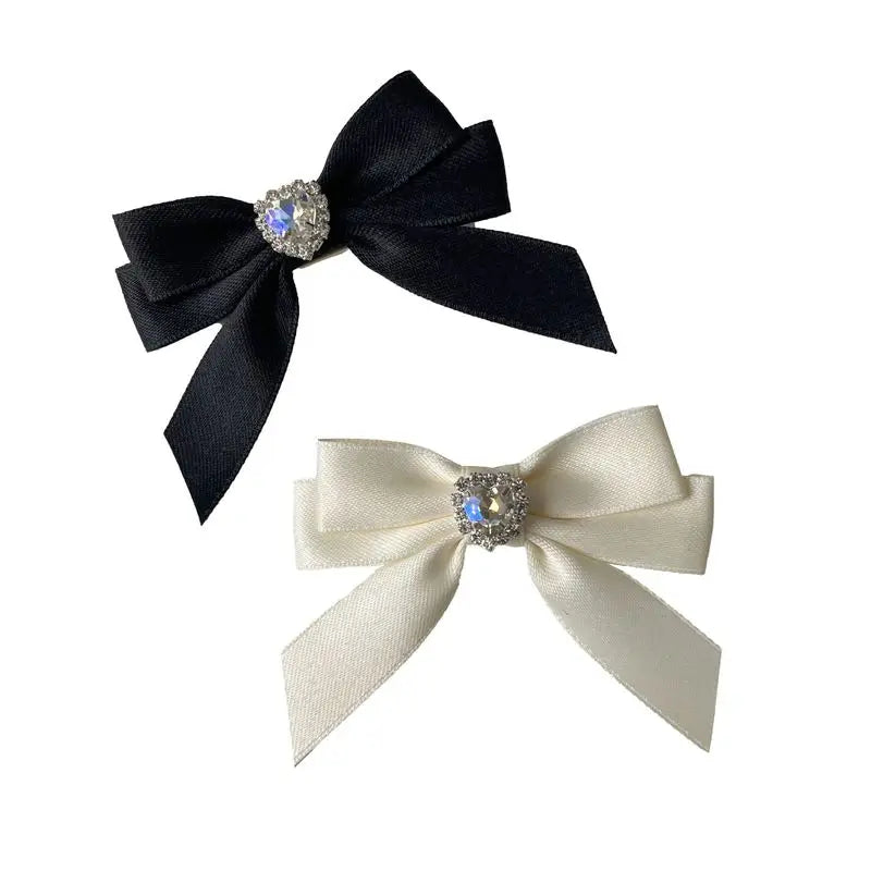 Black satin bow with a rhinestone heart embellishment for a hair clip
