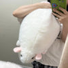 A white plush rat stuffed animal held by a person, viewed from the side.