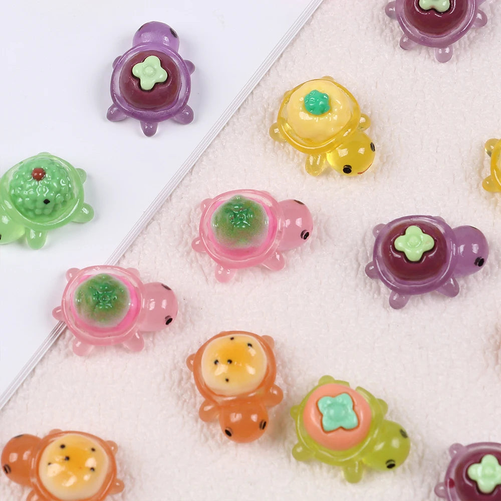 A collection of mini glow-in-the-dark turtle resin figurines in various colors like purple, yellow, pink, and green.