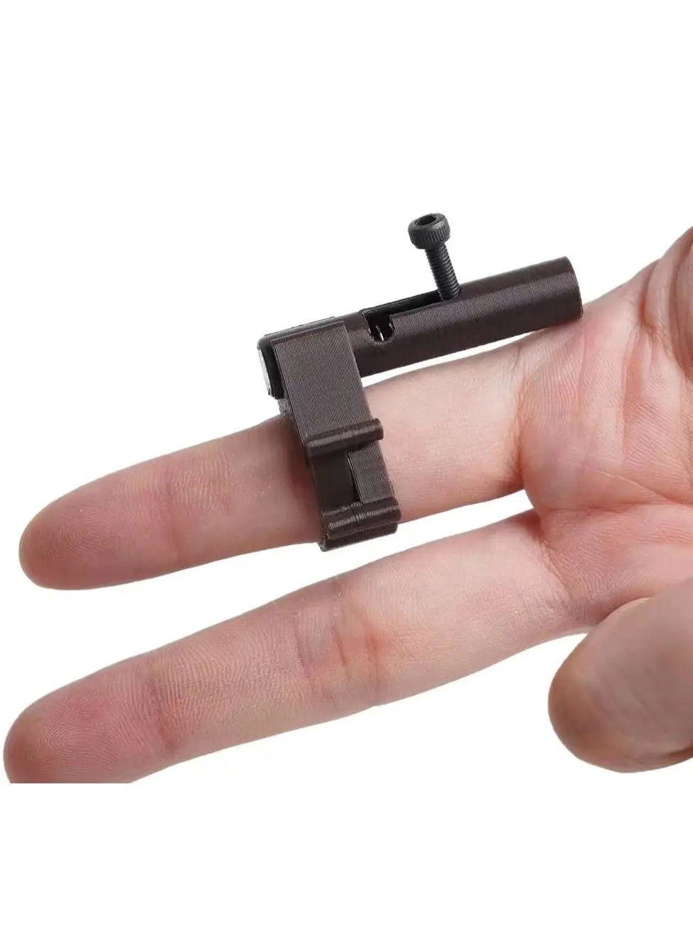 A hand holds a dark brown finger ring launcher keychain fidget toy with a small metal pin.