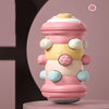 A pink and yellow Montessori baby crawling roller toy for tummy time with large eyes and various colored parts.
