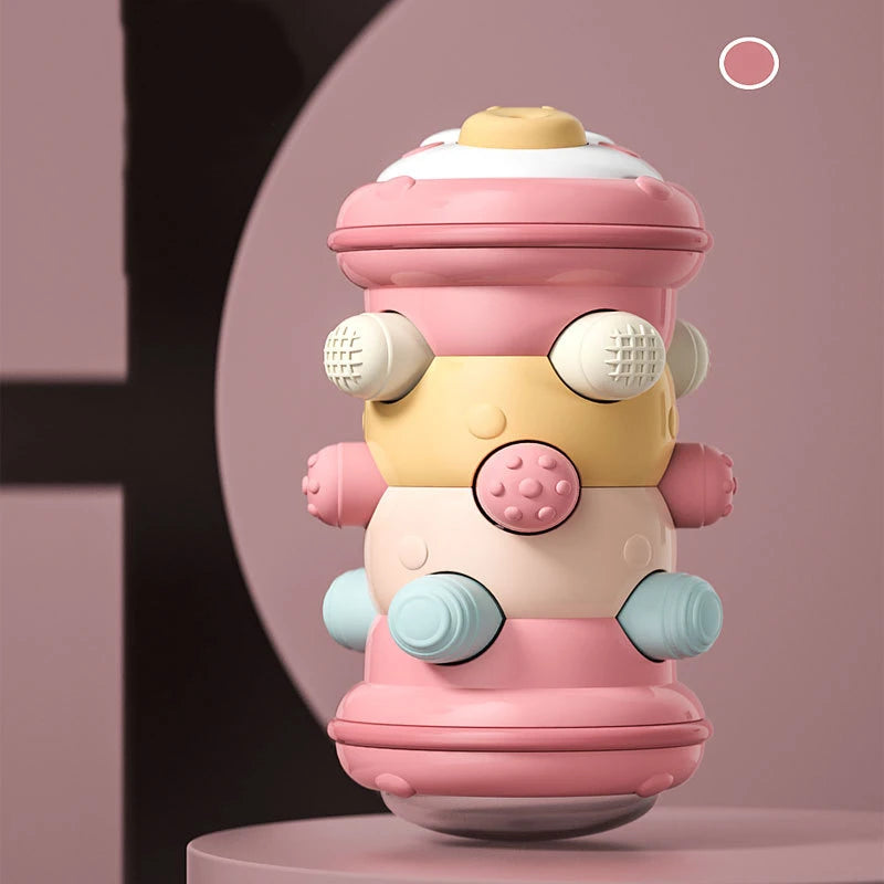A pink and yellow Montessori baby crawling roller toy for tummy time with large eyes and various colored parts.