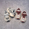 Three pairs of gray and red breathable mesh kids running sneakers with cushioned soles displayed on a gray surface.