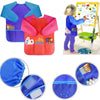 A bright pink and orange waterproof kids art and baking apron with long sleeves shown on a child.