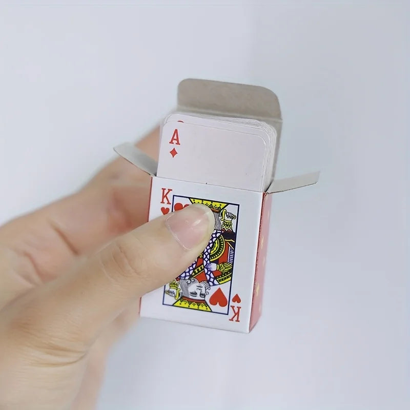 A hand holds a pink mini playing card set featuring a King of Hearts.