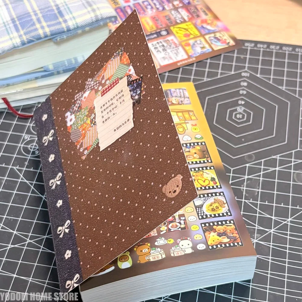 A close-up of a brown sticker book with decorative elements and colorful pages resting on a black grid surface.