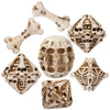 A set of carved bone skull polyhedral dice showing various shapes and numbers.