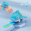 A blue turtle-shaped water gun is shown next to a measuring tape, demonstrating its use for splash fun.
