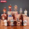 A collection of Hirono Sanctuary Series collectible figurines in various outfits and poses displayed on a wooden surface.