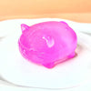 A bright pink silicone cat squishy toy resting on a white surface.