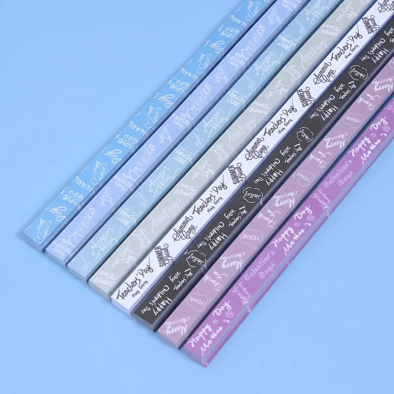 A collection of 27 assorted colored origami star strips laid out diagonally on a light blue surface.